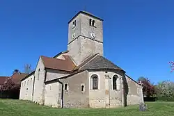 Blick auf die Kirche Saint-Antoine de Salornay-sur-Guye aus dem 11. Jahrhundert im romanischen Baustil, mit einem sehr massiven Turm und starken Mauern, die eher schlicht wirken und wenig Verzierungen aufweisen.