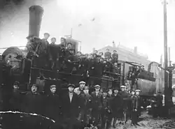 Eisenbahner posieren auf einer Lokomotive der Baureihe O