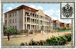 farbige Ansichtskarte mit einem Gebäude und dem Reichsadler rechts oben