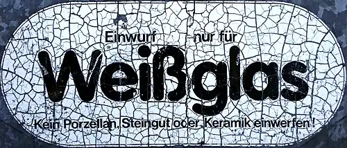 Verwitternder Hinweis an einem Glas-Recycling-Container