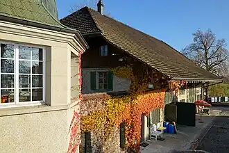 Überreste der einstigen Umfassungsmauer und ein als Scheune genutztes Nebengebäude