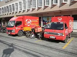 Foto zweiter roter Klein-LKW und mehrerer Motorräder