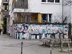 Reichenberger Straße in Berlin-Kreuzberg: Wand mit aufgeklebten Papierplakaten, die den Schriftzug „Catcalling is violence“ zeigen.