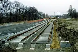 Zwi­ckau­er Stra­ße (Leip­zig), tief­lie­gen­de Ra­sen­gleise im Bau. Die Fahr­bahn­bal­ken lie­gen auf Stütz­punk­ten auf und bil­den pro Gleis zwei ne­ben­ein­an­der­lie­gen­de un­ter­ir­di­sche Brü­cken. Die Gleis­lage wird durch elas­ti­sche Bei­la­gen zwi­schen Fahr­bahn­bal­ken und Schwel­len re­gu­liert, re­gel­mä­ßi­ges Stop­fen ist nicht er­for­der­lich und auch nicht mög­lich.