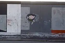 Gaston Lagaffe bricht durch die Berliner Mauer an der East Side Gallery, 1991