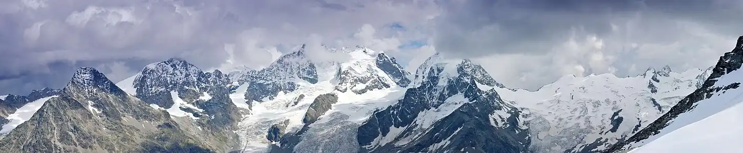 Piz Tschierva, Piz Morteratsch, Piz Palü, Biancograt, Piz Alv, Piz Bernina (im Nebel), Piz Scerscen und Piz Roseg (von links), aufgenommen von der Bergstation Corvatsch im Skigebiet Corvatsch-Furtschellas.