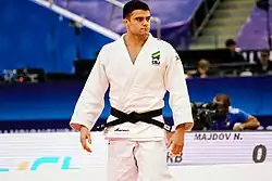 Macedo steht im weißen Judogi mit Brasilien-Aufnäher