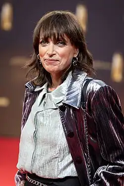 Anna Thalbach auf rotem Teppich vor Sponsorenwand