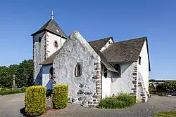 Grauweißes Kirchengebäude, leicht perspektivisch verzerrt.