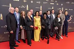 Gruppenaufnahme der Jury des Deutschen Fernsehpreises 2024 vor Sponsorenwand am Roten Teppich