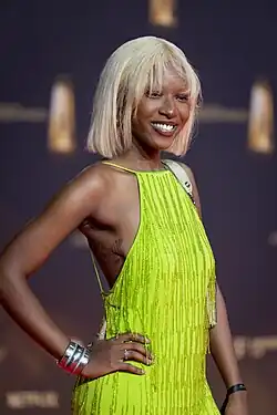 Jobel Mokonzi (Oberkörperportrait) in einem gelben Kleid
