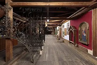 Die Wände im Schaulager sind in liturgischen Farben gehalten. Links das Chorgitter von 1891, 2019