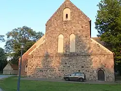 Westgiebel mit Dachansatz einer Vorhalle, oberhalb und um das Spitzbogenportal Quadermauerwerk