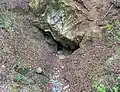 Der Höhleneingang von der nahegelegenen Straße aus gesehen