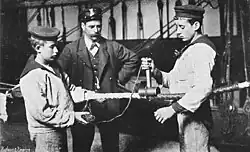 Kleedkeule in der Anwendung. Der zweite Mann hilft beim Kleeden mit der „Hüsingpuppe“ (Abwickeln der Garnspule)