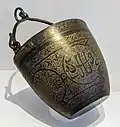 Nasrid Situla aus der Alhambra, 14. Jahrhundert, links und rechts zwei Attaschen mit Ringösen zum Einhängen des Henkels.