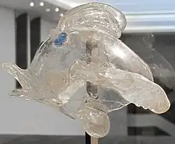 Fischförmiges Fläschchen aus entfärbtem Glas, die Augen aus blauem Glas aufgesetzt