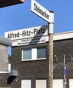Straßenschild am "Bergheimer Markt" Duisburg-Rheinhausen: Alfred-Hitz-Platz. Mit dem Zusatz: Alfred Hitz – Rheinhauser – Widerstandskämpfer – ermordet 1935