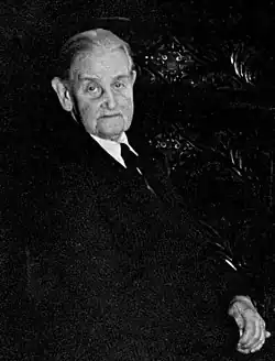 Annie McCall. Schwarz-Weiß-Foto einer alten Dame im Anzug. Auffällig sind auf dem dunklen Foto die großen Ohren.