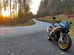 Aprilia Tuono V4 R von (2014) mit goldenen Schmiedefelgen, Umbau auf Heck der RSV4, Lenkerendenspiegel und Akrapovic-Endschalldämpfer