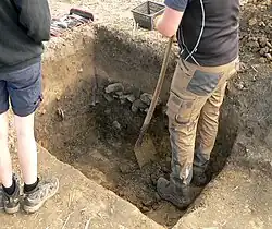 Dunkle Bodenverfärbung mit Steinen, Abfallgrube oder Grubenhaus