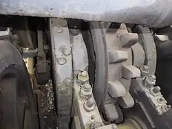 Hintere Zahnradachse mit linker Bandbremse, linker Rahmenwange, zweilamelligem Triebzahnrad System Abt, rechter Rahmenwange und rechter Bandbremse.