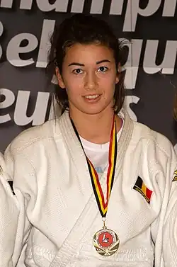 Willems trägt einen weißen Judogi. An einem Halsband in den belgischen Landesfarben ist ihr Medaille befestigt.