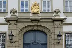 großes Eingangsportal, darüber goldenes Wappen von Kaiser Heinrich II und Kunigunde