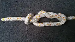 Nun legt man die Schlinge unten durch.