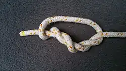 Nun nimmt man das Auge oder auch die Schlinge und legt sie nach oben. Beachtet aber dabei, dass sie links von der ersten Wicklung liegt