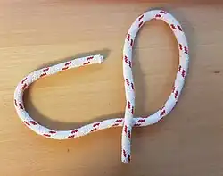 Man knüpft ein Auge, indem man mit der laufenden Part eine Bucht knüpft und diese Part unter die eigene stehende Part durchführt.