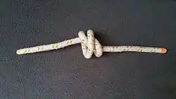 Den Knoten an beiden Tampen (Enden) ziehen und dabei die äußeren Törns nach innen drücken.