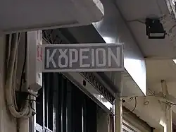 Aushängeschild eines griechischen Barbiers mit der ου-Ligatur „ȣ“