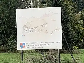 Bauschild mit Hinweis auf Umbau des Stadels zur Kindertagesstätte, 2023