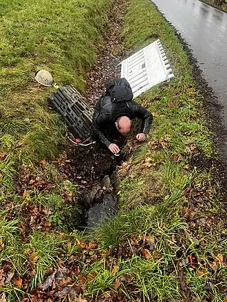 Der Höhlenforscher Stefan Voigt begutachtet den Feldbachponor, um den Arbeitsaufwand der Sicherung festzustellen.