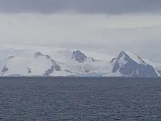 Blick von der Bransfieldstraße auf den Benkowski-Nunatak (Bildmitte) zwischen dem Parchevich Ridge (links) und dem Bogdan Ridge (rechts)