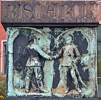 Zwei deutschen Soldaten besiegeln per Handschlag unter Eichenbäumen die Deutsche Einigung.