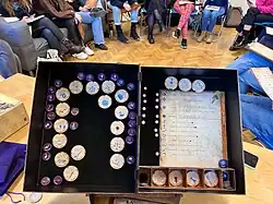 Das "Grimoire" des Spiels zeigt dem Erzähler den Spielstand, entsprechend den im Kreis sitzenden Spielern