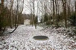 Schrei, 1991/92, Schacht 210 × Ø 139 cm, Kugel 75 cm, Gitter 2,5 × 128,5 cm, Mundhöhle 8 × 8 × 14 cm. Standort: im Tal (Skulpturenpark) zwischen Hasselbach und Werkhausen.