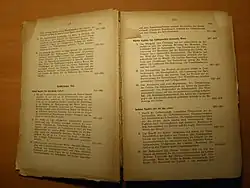 Foto eines aufgeschlagenen antiquarischen Buches. Die Seiten sind durch Alterung des säurehaltigen Papieres beschädigt.