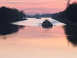 Bugwellen eines Schiffes und einiger Wasservögel im Rhein-Herne-Kanal