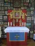 Der Altar, umgeben von Votivbildern