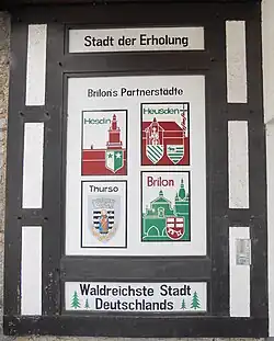 Holztafel im Fachwerkstil, die Brilons vier Partnerstädte ausweist