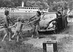 „Erholung am Flussufer“: Familie mit KdF-Wagen und tragbarem Röhrenempfänger (um 1940)