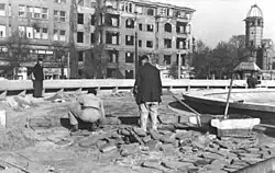 Kriegsschäden auf der Nordseite des Reichskanzlerplatzes, im Hintergrund rechts die Ruine der Villa Tanneck, 1948