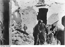 Deutsche Sanitäter bei der Bergung von Verwundeten unter dem Schutzzeichen des Roten Kreuzes bei der Schlacht um Monte Cassino (Januar 1944).