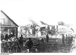 Wehrmachtssoldaten beobachten die von Kollaborateuren niedergebrannte Synagoge. NS-Propagandafoto vom Juni 1941