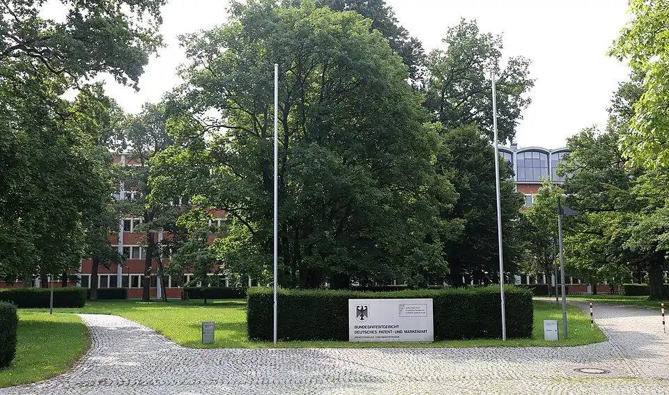 Grünfläche mit Bäumen vor dem Gebäude des Bundespatentgerichts, hier ausnahmsweise auch mit Hecken