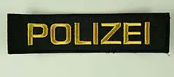 Schriftzug auf den Uniformen der Polizei