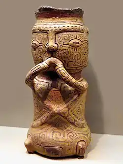 Begräbnisurne in Gestalt einer Tierfigur mit Augen, Nase, Mund und Armen und verziert mit Graphismen